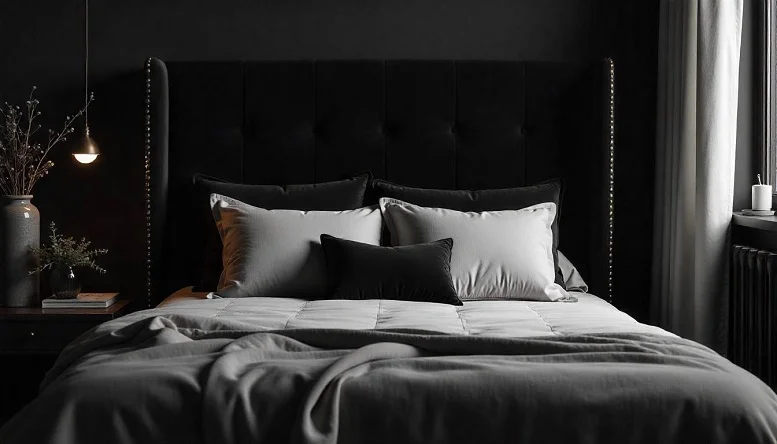 Black bedroom with a plush velvet headboard and layered bedding, creating a luxurious and elegant centerpiece. 