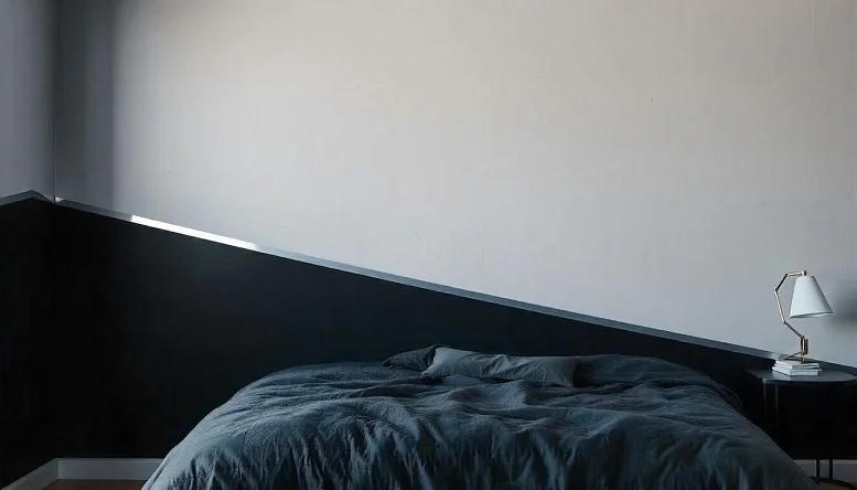 Two-tone black and grey bedroom walls with minimal decor. 